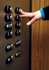 a hand pressing floor call buttons in an elevator