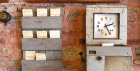 Vintage time clock with punch cards to physically mark when an employee starts and ends their shift.