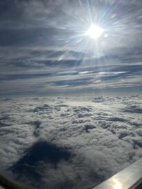 The sun and clouds from an airplane window.