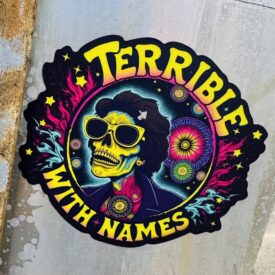 Psychedelic sticker design. A skull wearing shades look up among a field of bright flowers. Around the edge are the words: Terrible with Names.